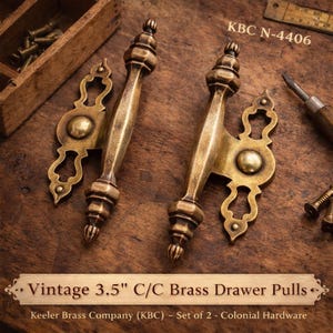 May include: Two vintage brass drawer pulls, each 3.5 inches (8.89 cm) center to center, with ornate detailing. The pulls have a warm, antique finish and are labeled "KBC N-4406". The text "Vintage 3.5" C/C Brass Drawer Pulls" is also visible.