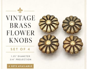 May include: A set of four brass flower knobs with a dark, aged finish. The text reads: VINTAGE BRASS FLOWER KNOBS, SET OF 4, 1.25" DIAMETER, 3/4" PROJECTION, 4 SETS AVAILABLE. Each knob features a circular center with radiating petal-like segments.