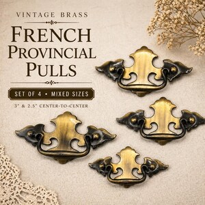May include: Four vintage brass French Provincial pulls with a dark patina. The pulls have a decorative design and are available in mixed sizes, 3" and 2.5" center-to-center. The text "VINTAGE BRASS" and "FRENCH PROVINCIAL PULLS" is visible.