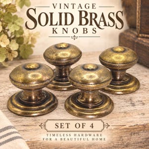 May include: A set of four round solid brass knobs with a weathered, dark gold finish. The text VINTAGE SOLID BRASS KNOBS is displayed at the top, and SET OF 4 TIMELESS HARDWARE FOR A BEAUTIFUL HOME is printed at the bottom of the image.
