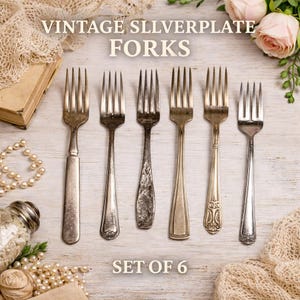May include: Set of six vintage silverplate forks with varying handle designs. The forks are arranged on a light-colored wooden surface, with the text "VINTAGE SILVERPLATE FORKS" and "SET OF 6" displayed. Decorative elements include pearls and flowers.