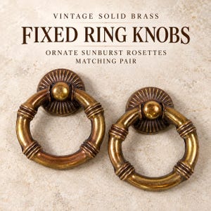May include: A matching pair of solid brass fixed ring knobs with ornate sunburst rosettes. The text reads: VINTAGE SOLID BRASS FIXED RING KNOBS ORNATE SUNBURST ROSETTES MATCHING PAIR. The circular rings feature a segmented, bamboo-like design.