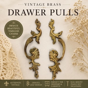 May include: Two vintage brass drawer pulls featuring an ornate leaf design with scrollwork details. The hardware includes mounting holes at the top and bottom of each piece. The text VINTAGE BRASS DRAWER PULLS is visible at the top of the image.