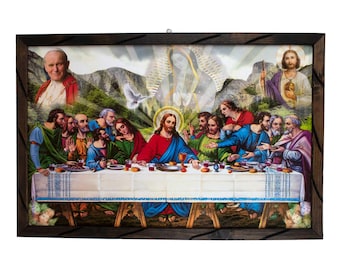 May include: A framed religious artwork depicting the Last Supper, with Jesus and his disciples at a table. The artwork features vibrant colors and is set against a backdrop of mountains and other religious figures. The frame is dark wood.