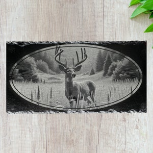 May include: Black and white engraved slate coaster featuring a detailed image of a white-tailed deer with large antlers standing in a forest clearing.