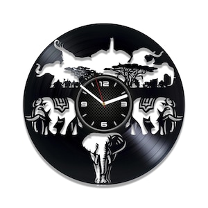 May include: Black vinyl record clock with a white silhouette of elephants and trees. The clock face is black with white numbers and hands.