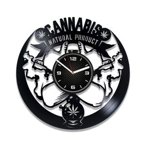 Può includere: Orologio in vinile nero con un design a foglia di cannabis e il testo "Cannabis Prodotto Naturale". Il quadrante dell'orologio è nero con numeri e lancette bianchi.