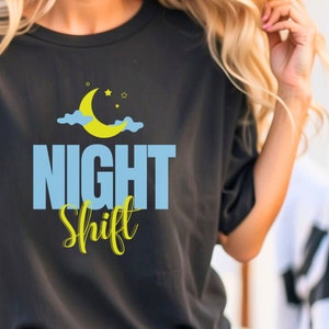 May include: Black t-shirt with a yellow crescent moon and clouds graphic and the text "NIGHT Shift" in blue and yellow lettering.