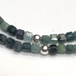 May include: A double strand necklace made with small, square, green and blue gemstone beads and silver spacer beads.