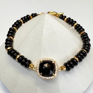 Black onyx stone bracelet accented with an elegant faceted black onyx 18k gold plated brass and cubic zirconia center