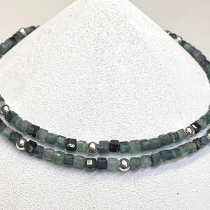 May include: A double-strand necklace made of green and blue gemstone beads with silver spacer beads.