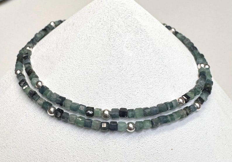 May include: A double-strand necklace made of green and blue gemstone beads with silver spacer beads.