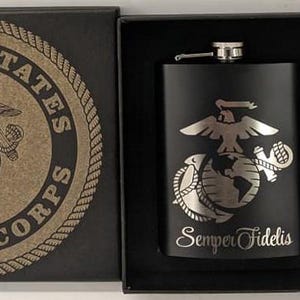 May include: A black gift box with a black flask and two shot glasses. The flask and glasses are engraved with the United States Marine Corps emblem and the words "Semper Fidelis".