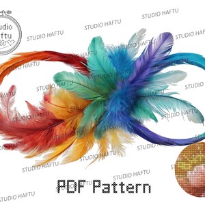 May include: A colorful feather design with the text "Studio Haftu" repeated throughout the image. The text "PDF Pattern" is also included in the image. The design is a circular pattern of feathers in shades of red, orange, yellow, green, blue, and purple.