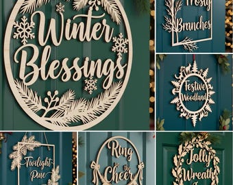 May include: A collection of wooden Christmas wreaths with various designs and text. The wreaths include phrases like "Winter Blessings," "Frosty Branches," and "Jolly Wreath Joy." Each wreath is made of light-colored wood and features intricate cut-out details.