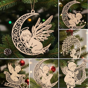 Puede incluir: Adornos navideños de madera con diseños de ángeles. Uno muestra un ángel durmiendo en una luna creciente. Otros adornos representan ángeles con alas, tocando el arpa, leyendo un libro y en un trineo. Cada adorno está hecho de madera clara.
