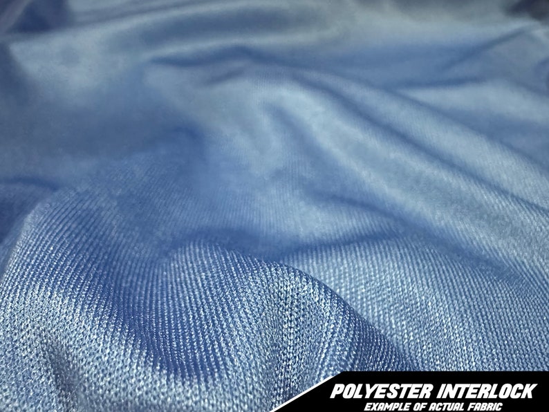 May include: Close-up of a light blue polyester interlock fabric. The fabric is textured and has a slight sheen. The image includes the text "POLYESTER INTERLOCK EXAMPLE OF ACTUAL FABRIC" in the bottom right corner.