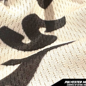 May include: Close-up of a beige polyester mesh fabric with black abstract shapes. The fabric has a textured, open weave. The bottom of the image has the text "POLYESTER MESH EXAMPLE OF ACTUAL FABRIC".