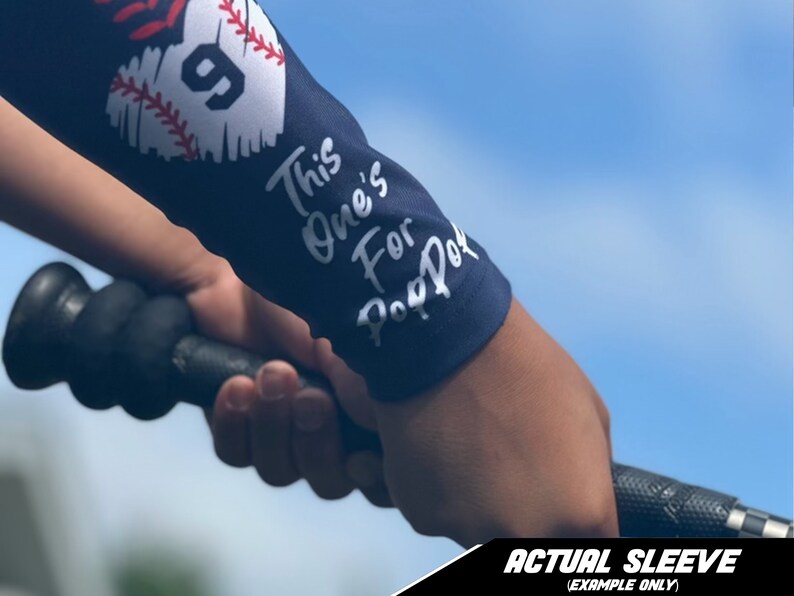 May include: A navy blue baseball sleeve with a white baseball graphic and the text "This one's for Pop Pop".