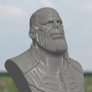 May include: A gray 3D printed bust of Thanos, a character from the Marvel Cinematic Universe. The bust features a detailed depiction of Thanos's face, including his chin, beard, and wrinkles. The bust is wearing a detailed, textured armor with a geometric pattern.