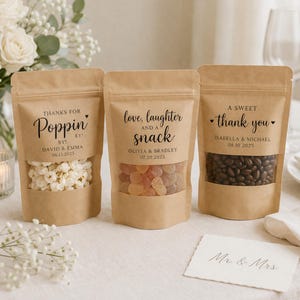 May include: A white ceramic mug with a black handle and the text "But First, Coffee" in a bold, black font. The mug is set against a blurred background, suggesting a cozy setting. The mug appears to be approximately 4 inches tall.