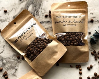 Puede incluir: Dos bolsas de papel marrón con ventanas de plástico transparente llenas de granos de café. Las bolsas tienen etiquetas que dicen "The Perfect Blend" con una fecha de boda y los nombres de la pareja.