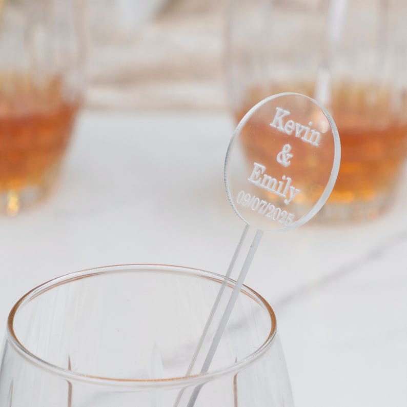 May include: Clear acrylic drink stirrer with a round disc that says "Kevin & Emily 09/07/2023".