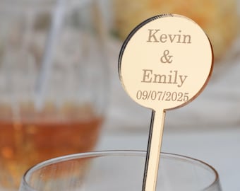 May include: Gold-colored acrylic drink stirrer with a round topper. The topper has the text "Kevin & Emily 09/07/2025" engraved on it.