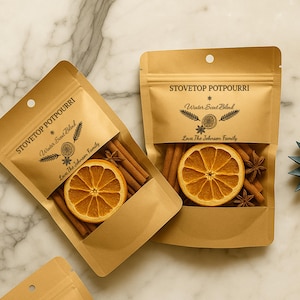 May include: Two kraft paper pouches of stovetop potpourri. Each pouch contains cinnamon sticks, star anise, and a dried orange slice. The text "STOVETOP POTPOURRI" and "Winter Scent Blend" are printed on the front. The phrase "Love The Johnson Family" is also printed on the front.