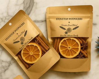 May include: Two kraft paper pouches of stovetop potpourri. Each pouch contains cinnamon sticks, star anise, and a dried orange slice. The text "STOVETOP POTPOURRI" and "Winter Scent Blend" are printed on the front. The phrase "Love The Johnson Family" is also printed on the front.