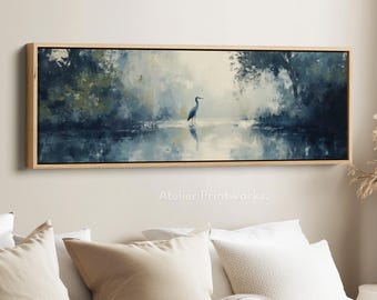Puede incluir: Pintura enmarcada de un paisaje acuático con una garza en el agua. La obra de arte presenta una paleta de colores apagados de azules, verdes y blancos, con un marco de madera natural. El texto "Atelier Printworks" es visible.