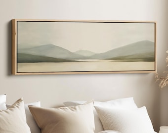 Puede incluir: Una pintura de paisaje que presenta una serena escena lacustre con montañas al fondo. La obra de arte está enmarcada en un marco de madera natural. La paleta de colores incluye tonos verdes, azules y beige apagados, creando una estética relajante.