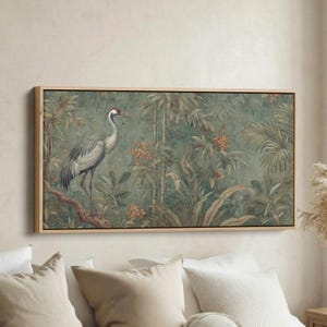 May include: A framed wall art print featuring a crane in a tropical forest scene. The artwork showcases a gray crane with a red head, perched on a branch amidst lush green foliage and bamboo. The background has a teal and green color palette.