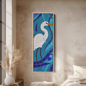 Könnte beinhalten: Ein Mosaikkunstwerk mit einem weißen Reiher vor einem Hintergrund aus blauen und türkisfarbenen Fliesen. Der Reiher hat ein rotes Auge und einen gelben Schnabel. Das Kunstwerk ist in einem hellen Holzrahmen gerahmt und schafft eine Wanddekoration.