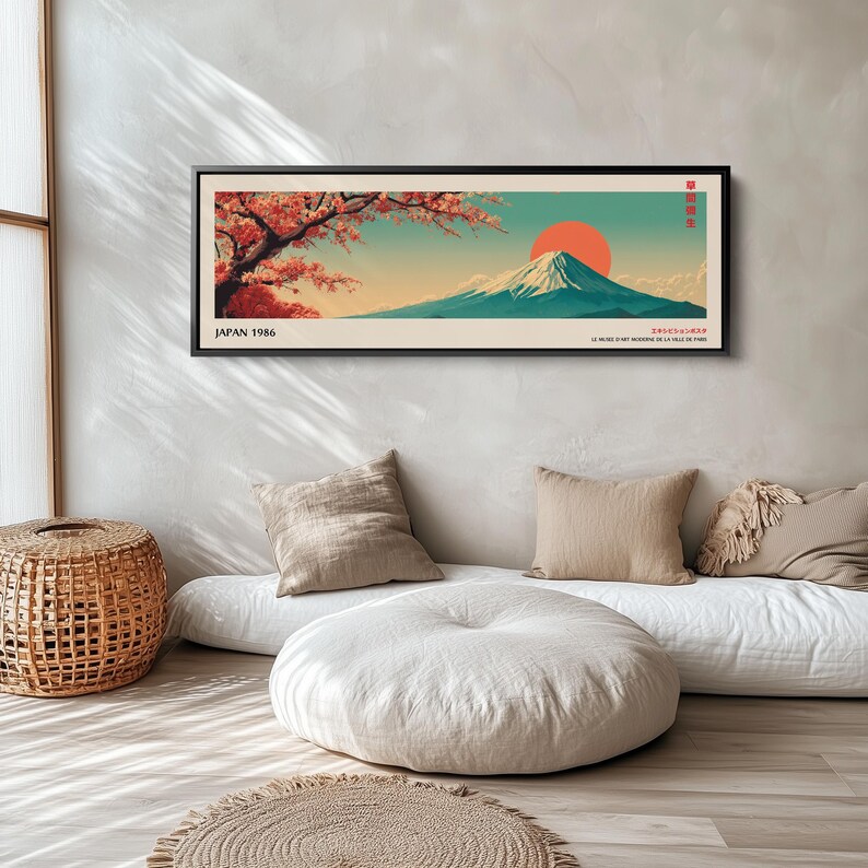 Puede incluir: Una impresi&oacute;n art&iacute;stica panor&aacute;mica enmarcada que muestra un paisaje con una monta&ntilde;a nevada, un gran sol naranja y ramas de cerezo. El texto JAPAN 1986 est&aacute; impreso en la esquina inferior izquierda, con texto japon&eacute;s a la derecha.