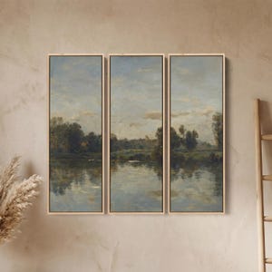 Könnte beinhalten: Triptychon-Wandkunst mit einem ruhigen Landschaftsgemälde. Das Kunstwerk zeigt eine friedliche Flussszene mit Bäumen und einem bewölkten Himmel, dargestellt in sanften Blau-, Grün- und Beigetönen. Jedes Panel ist in hellem Holz gerahmt.