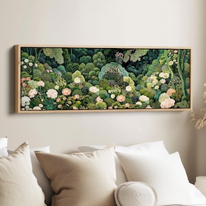Könnte beinhalten: Ein rechteckiges, panoramisches Wandbild in einem hellen Holzrahmen, das eine dichte, üppige Waldszene zeigt. Das Kunstwerk präsentiert eine Vielzahl von grünem Laub, Sträuchern und Bäumen, durchsetzt mit blühenden weißen, rosa und pfirsichfarbenen Blumen.