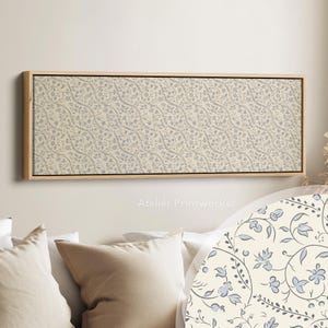 Peut inclure: Tableau rectangulaire encadré avec un fond crème et un motif floral répétitif en bleu clair et gris. L'œuvre est dans un cadre en bois naturel, une pièce décorative pour la décoration intérieure. Le cadre mesure environ 100 cm de long.