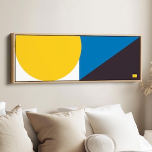 Puede incluir: Una pieza de arte mural rectangular en un marco de madera clara con una composición geométrica. El diseño incluye un gran círculo amarillo sobre fondo blanco, una sección vertical azul sólida y un triángulo marrón oscuro con un pequeño cuadrado amarillo.
