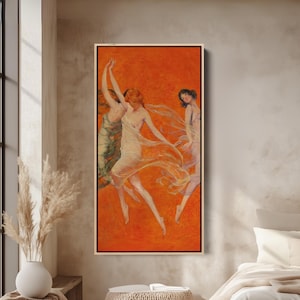 May include: A framed art print featuring three figures in flowing gowns dancing against an orange background. The artwork has a vintage aesthetic, with soft colors and a sense of movement. The figures are in shades of white, green, and pink.