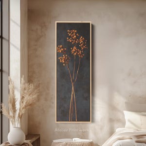 Op de afbeelding: Een ingelijste botanische print met gedroogde bloemen tegen een donkerblauwe achtergrond. Het kunstwerk heeft een natuurlijke houten lijst en wordt getoond in een neutrale kamer. De tekst "Atelier Printworks" is zichtbaar. Minimalistisch en natuurlijk thema.