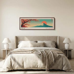Puede incluir: Una impresi&oacute;n de arte mural horizontal enmarcada que presenta un paisaje estilizado del monte Fuji con un gran sol naranja, ramas de cerezo en flor en primer plano, el texto JAPAN 1986 en la esquina inferior izquierda y caracteres japoneses a la derecha.
