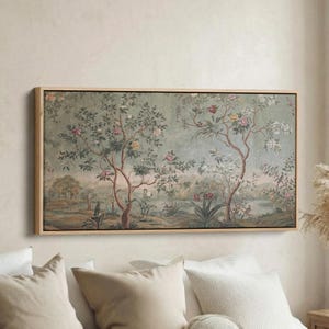 May include: A framed artwork depicting a landscape scene with trees, flowers, and water. The colour palette is muted, with greens, pinks, and beige. The frame is made of light-coloured wood. The artwork is suitable for home decor.