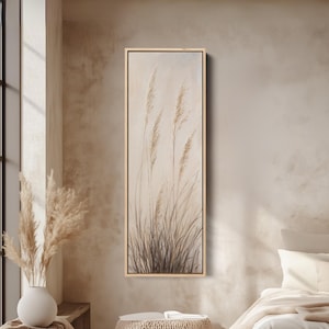 May include: A rectangular canvas art print depicting tall, dried grasses in beige and brown tones. The artwork is framed in light wood, creating a neutral and calming aesthetic. The painting evokes a sense of nature and tranquility, suitable for a bedroom or living room.