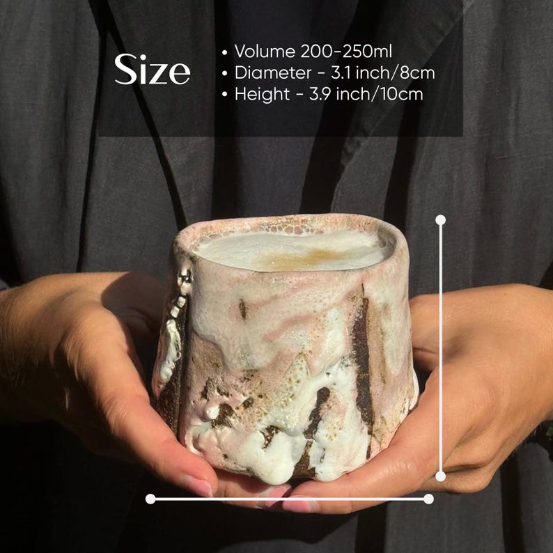 May include: A hand-crafted ceramic mug with a unique, textured, and slightly uneven surface. The mug is a light pink and brown color with a white glaze. It has a capacity of 200-250 ml, a diameter of 3.1 inches (8 cm), and a height of 3.9 inches (10 cm).