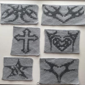 Peut inclure: Six carrés en crochet gris avec différents motifs noirs. Les motifs comprennent une croix, un cœur, un papillon et une étoile.