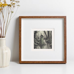 Peut inclure: Une illustration en noir et blanc encadrée d'une figure debout dans une forêt. Le cadre est en bois foncé et possède un passe-partout blanc. L'illustration est placée contre un mur blanc avec un vase de fleurs jaunes séchées.
