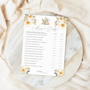May include: A printable baby shower game with a floral design. The game asks guests to guess who will do more of certain things, like who will take more baby photos, who will change more diapers, and who will sing the most lullabies. The game has two columns for Mom and Dad.