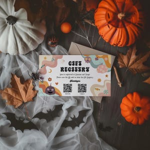 Może przedstawiać: Karta rejestru prezentów o tematyce Halloween z napisem "Gift Registry" w stylu retro. Karta zawiera ilustrację dyni, kody QR i jest otoczona dyniami, liśćmi i dekoracyjnymi nietoperzami.