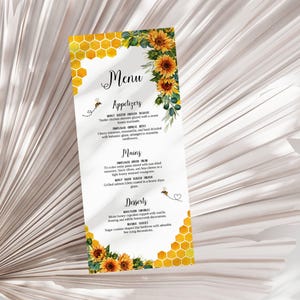 Może przedstawiać: Menu z motywem pszczoły i słonecznika. Menu zawiera wzór plastra miodu i akcenty słoneczników. Menu zawiera przystawki, dania główne i desery. Menu jest wydrukowane na białym papierze.